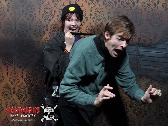 Scared man and woman reacting with fear in a funny haunted house photo taken during a fright moment.