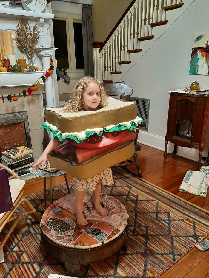 A young child dressed as a giant sandwich for kids Halloween costumes.