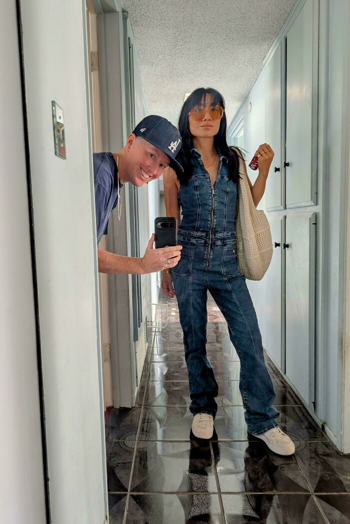 A woman wearing a denim jumpsuit that she bought as one of her thrift store finds