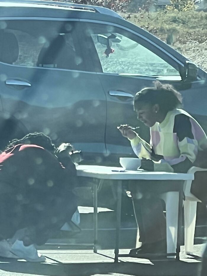 Influencers in public spaces setting up a table and dining in a parking lot
