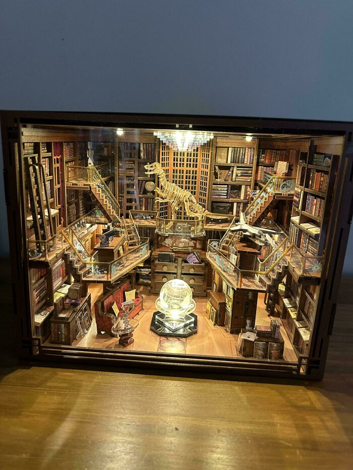 Grand library diorama featuring a dinosaur skeleton in book nooks