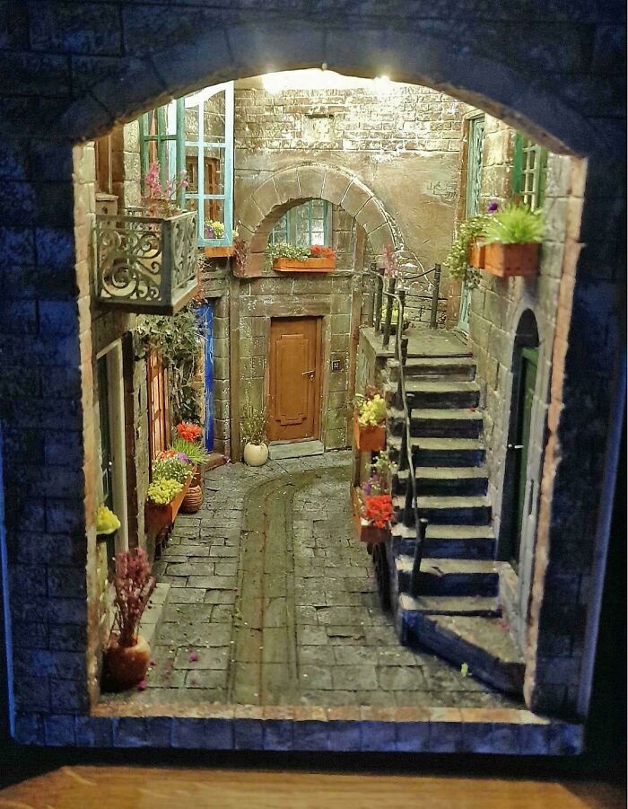 A detailed miniature book nook showing an old European alleyway