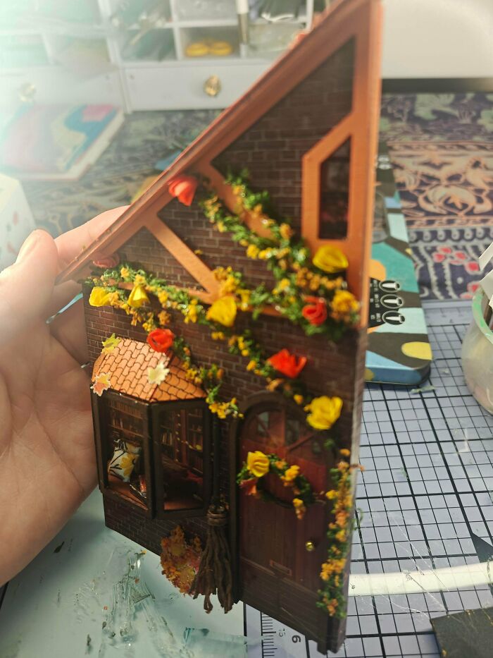 A detailed miniature brick storefront for a custom book nook shelf insert project.