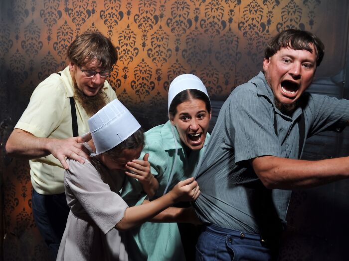 Funny haunted house photo of a group of terrified people in Amish clothing screaming in fear