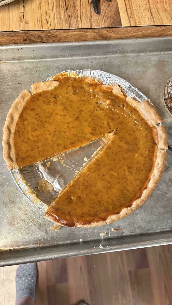 A pumpkin pie cut unevenly down the middle, showcasing husband's funniest quirks of serving food