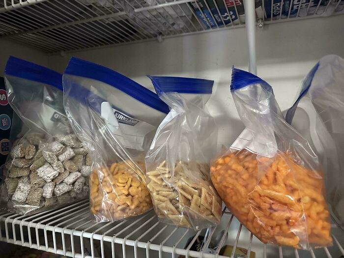 Four plastic bags of snacks stored in a pantry, showcasing funny husband quirks of organizing.