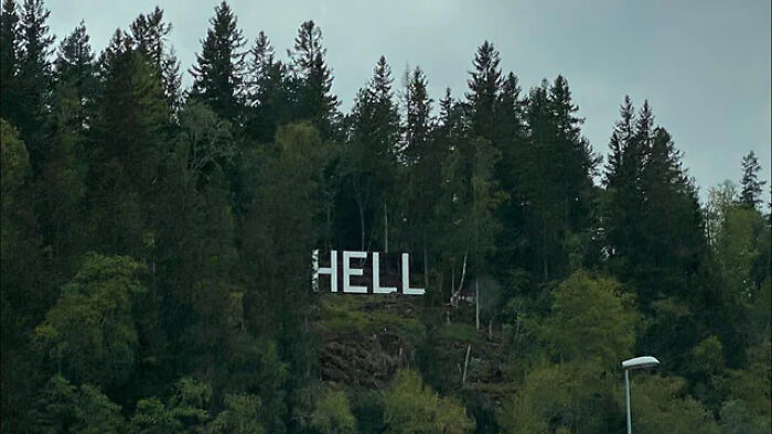 Large white letters spelling Hell on a forested hillside, showcasing unusual signs