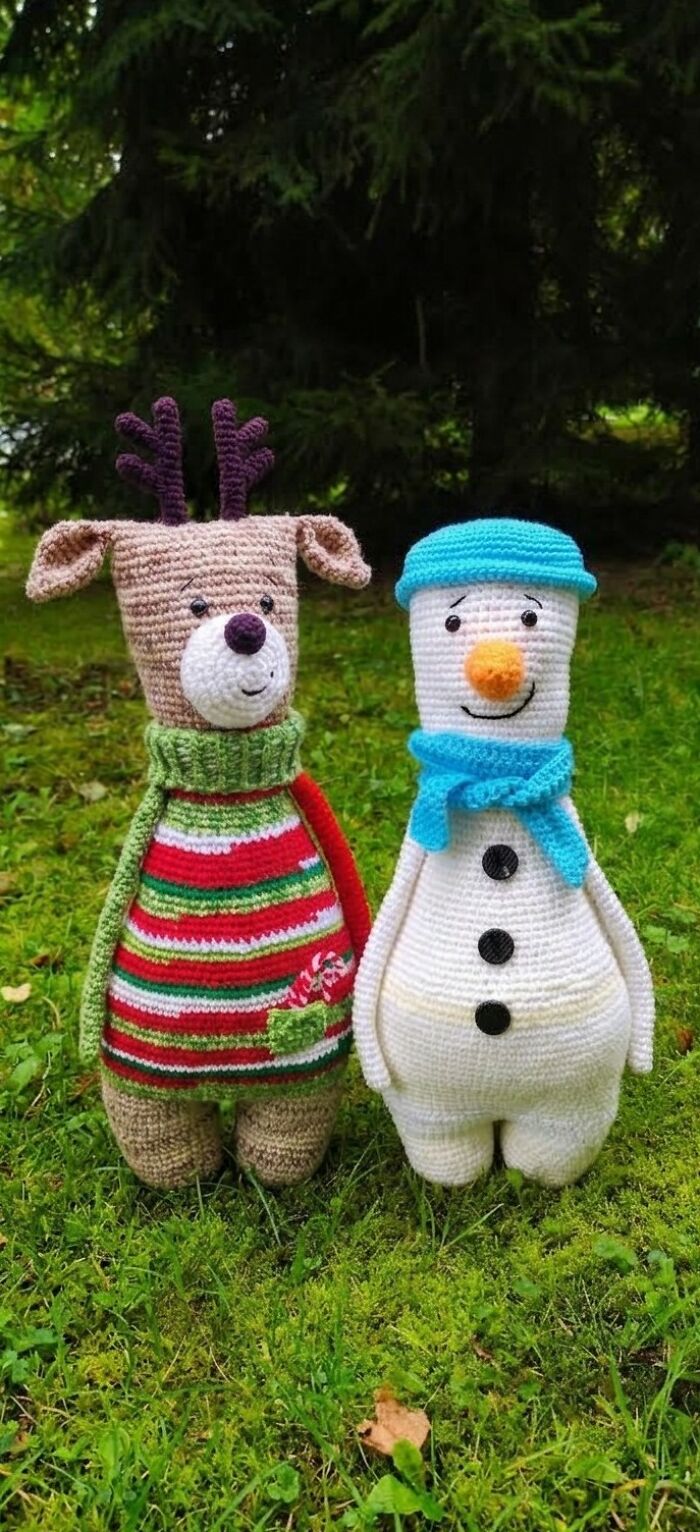 Two adorable crochet creatures, a reindeer and a snowman, standing on green grass.