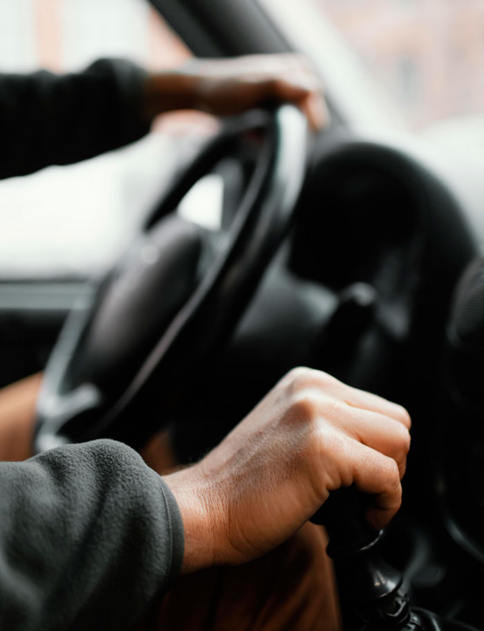 Hands on a steering wheel and gear shift representing life changes in divorce stories.