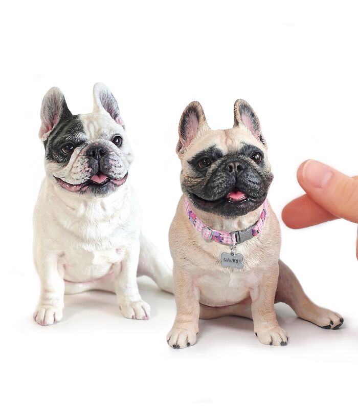 Two small hyperrealistic sculptures of French bulldogs, handmade with realistic fur details.