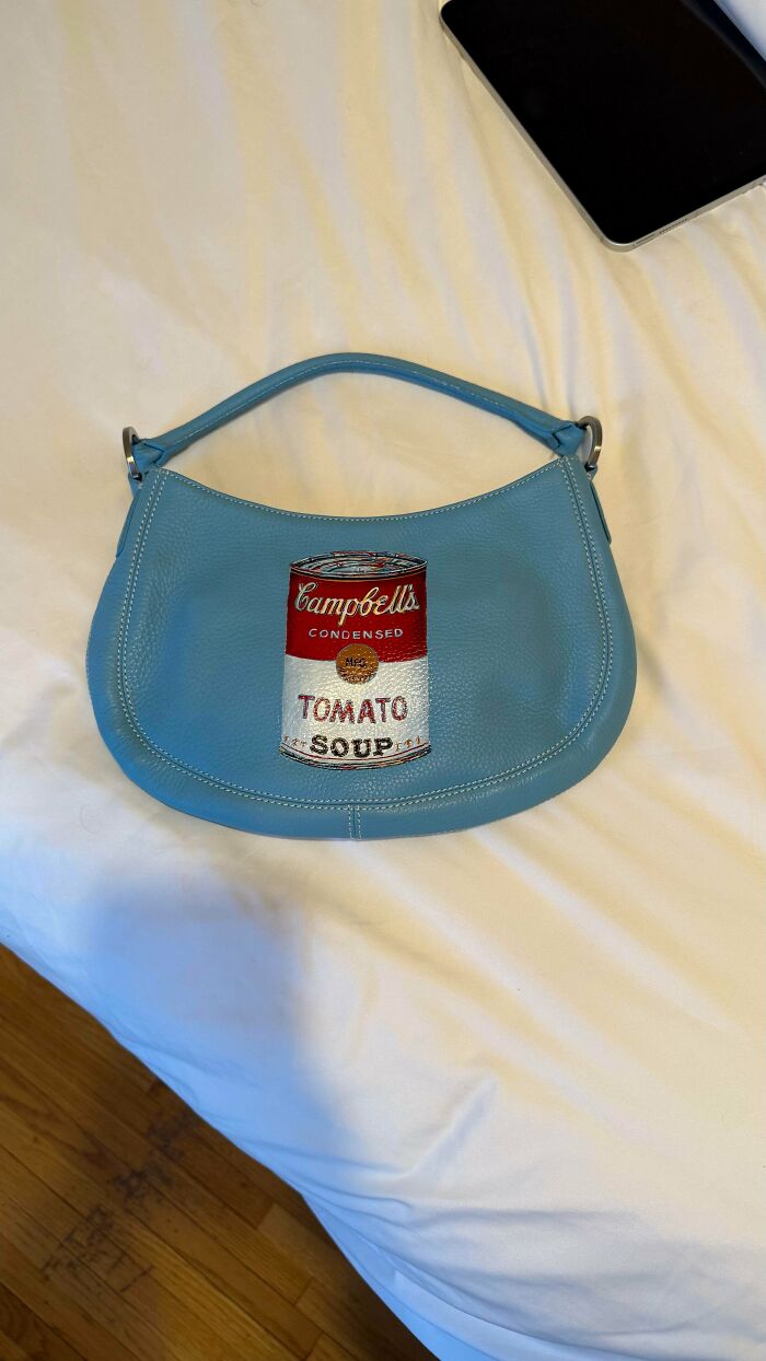 A light blue leather handbag with a Campbell's tomato soup can design, amazing thrift store finds.