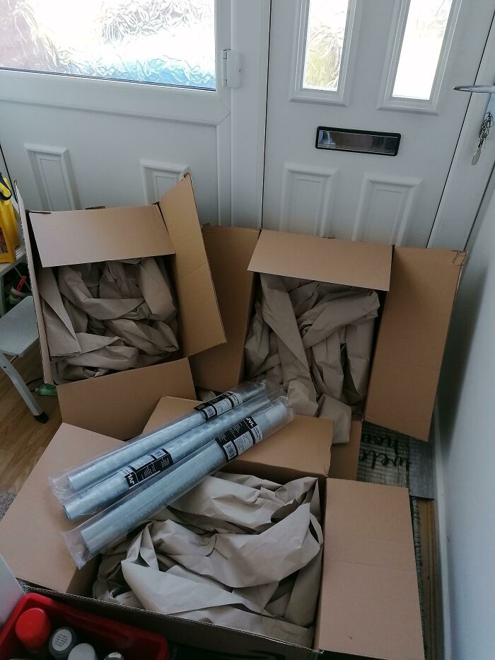 Three small plastic rolls sitting atop giant cardboard boxes filled with excess paper, bad packaging fails example