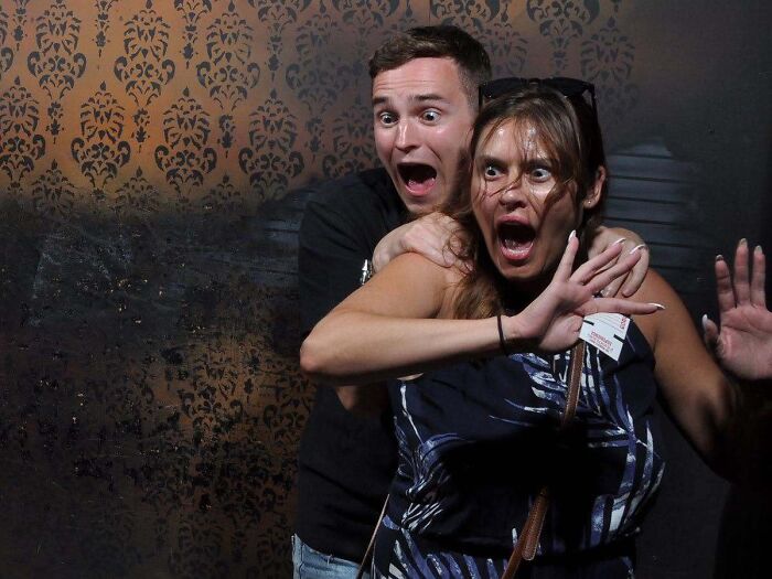 A shocked couple reacting with open-mouthed terror in memorable haunted house photos.