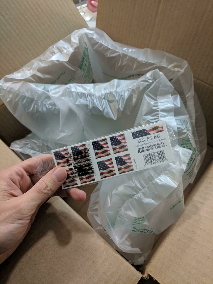 Small sheet of US Flag stamps inside a large box filled with air pillows depicting bad packaging fails