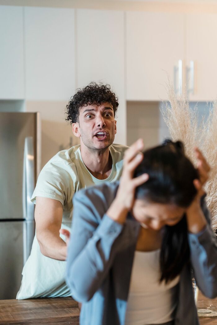 An angry man shouts at a stressed woman covering her ears, a sign of why marriages collapsed.