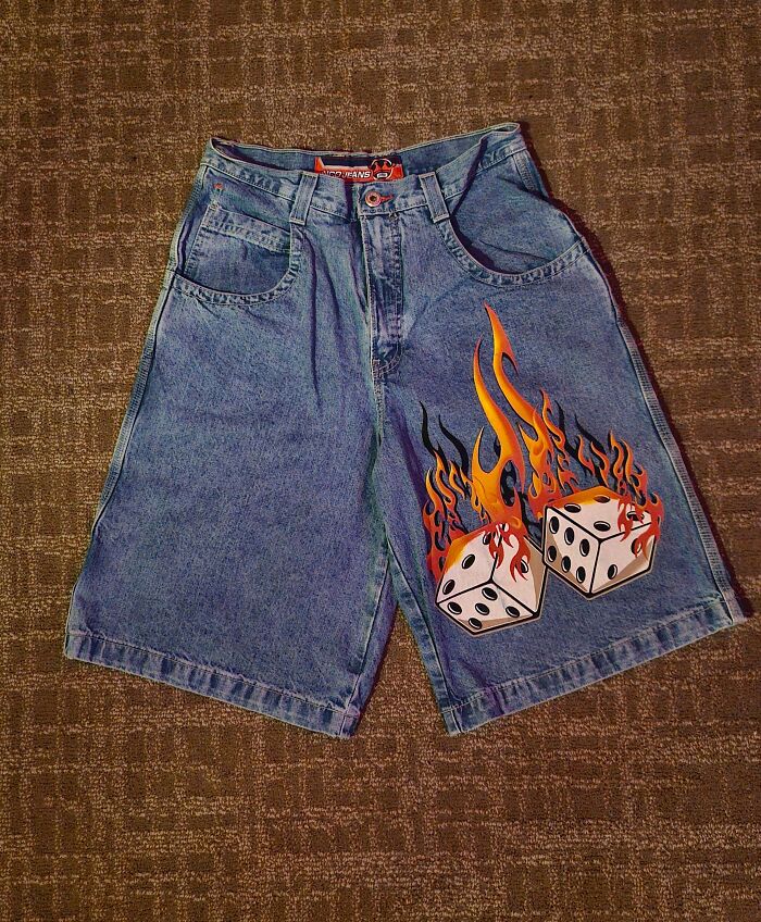 A pair of vintage denim shorts with a flaming dice graphic, unique thrift store finds.