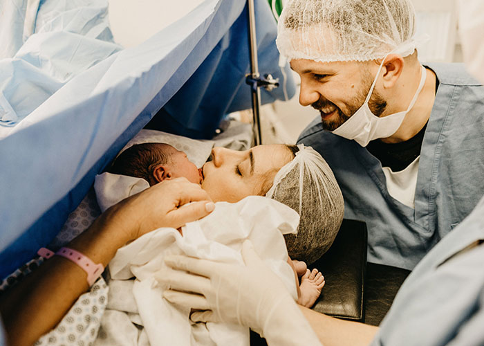 A happy mother embracing her newborn baby in the delivery room after giving birth.
