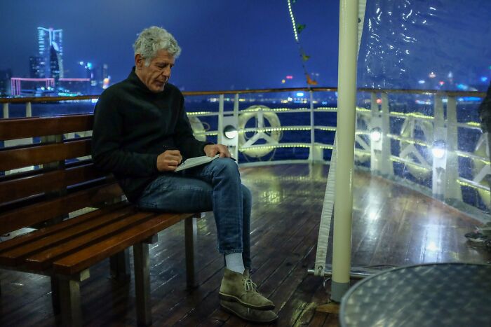 Anthony Bourdain writing in a notepad on a boat, captured in photos for the last time during a trip