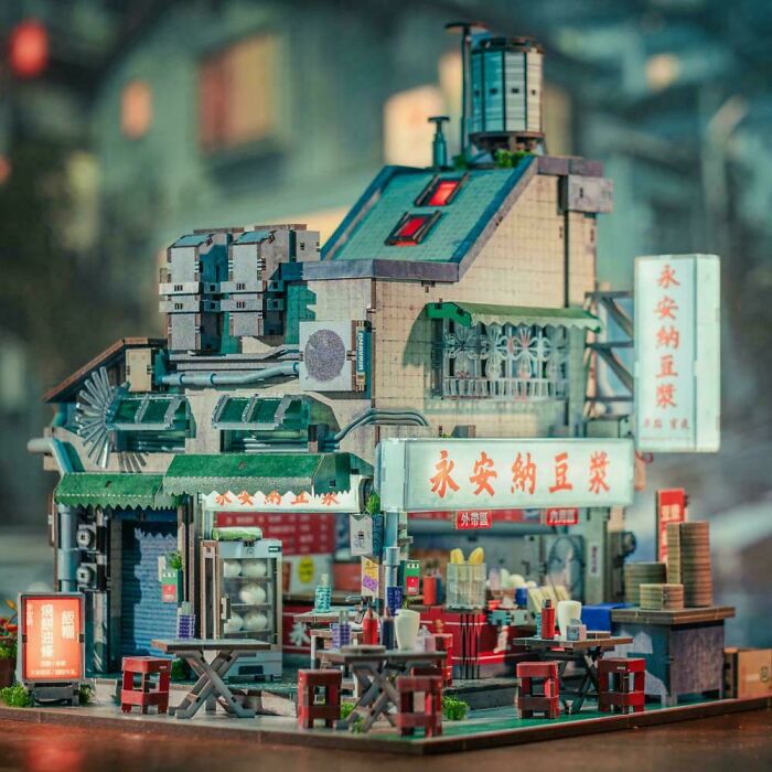 A miniature book nooks model of a cozy retro Chinese street cafe with lighted signs and tables