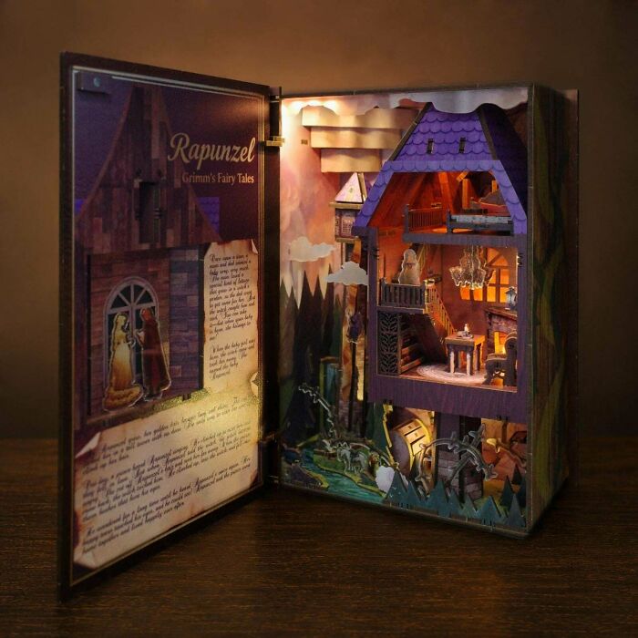 A detailed Rapunzel-themed book nook depicting a illuminated tower scene inside a wooden book.