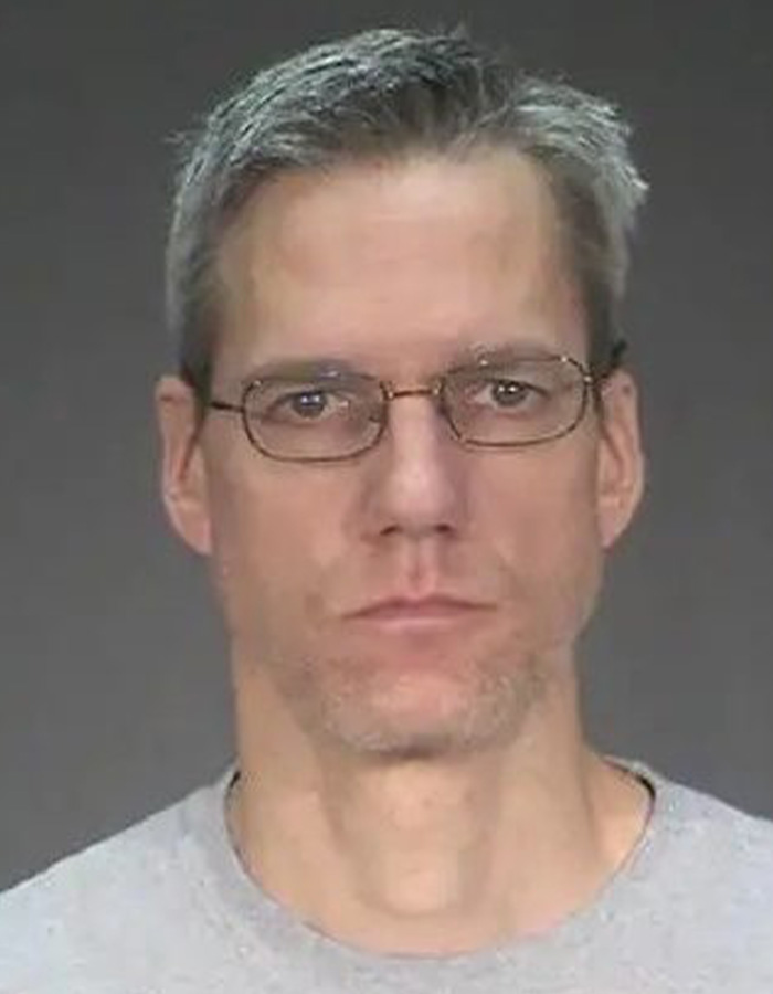 A mugshot of a middle-aged man wearing glasses from true crime stories