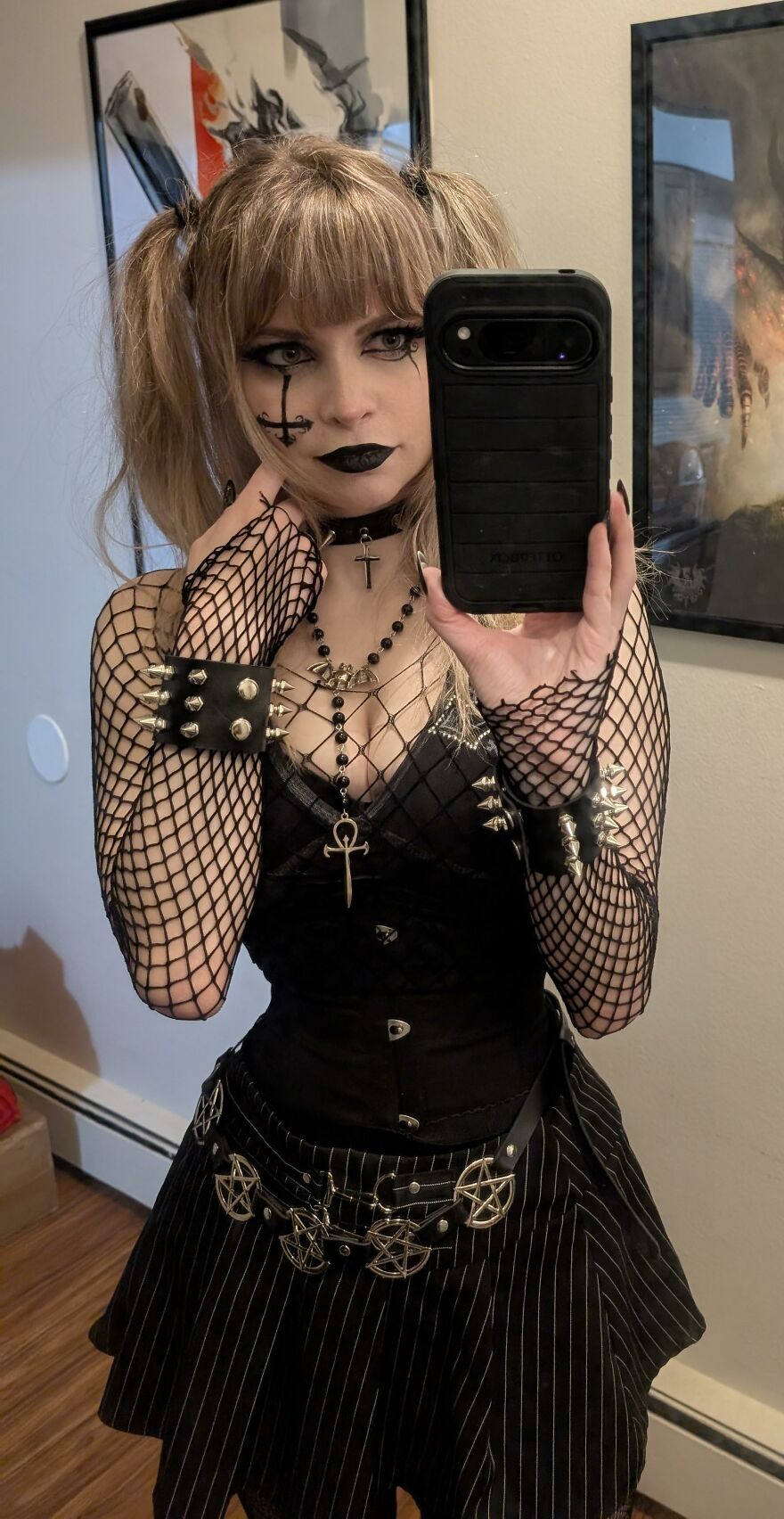Woman taking a mirror selfie dressed in dark gothic fashion for a creative Halloween costume idea.