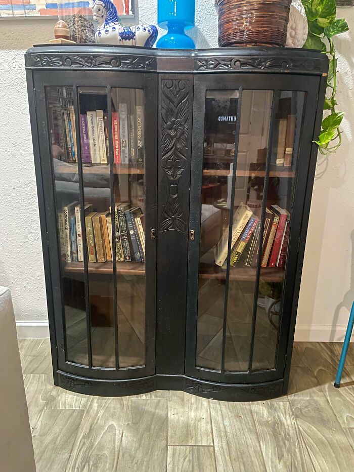 An elegant, vintage dark wood display cabinet with glass doors, a jewel among thrift store finds