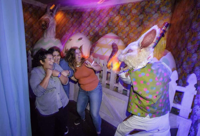 Panicked visitors scream as a creepy rabbit character jumps out inside a haunted house.