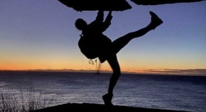 Silhouette of a person hanging from a cliff against sunset, captured in photos for the last time.
